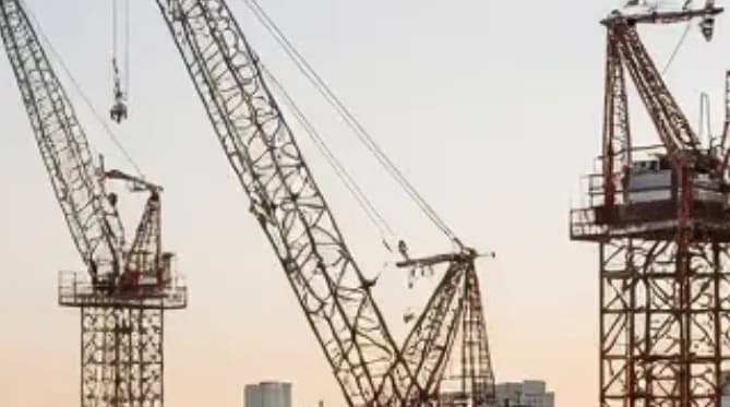 Tower cranes on a construction site at dusk