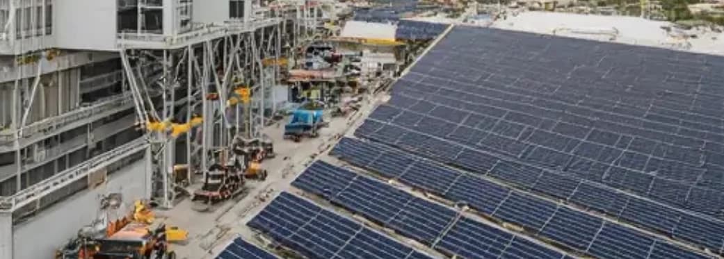 Solar panel installation beside an industrial facility